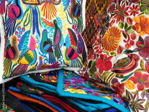 Close up of сolorful embroidered decorative textile and pillows from Otavalo city at the artisans market © Iryna