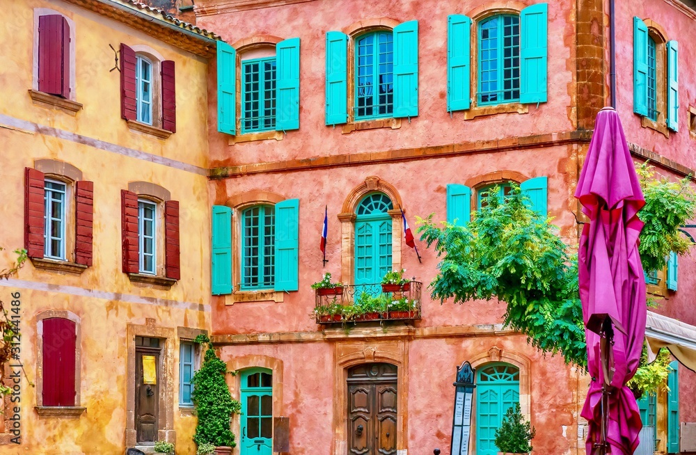 Beautiful, colorful building facades made from locally mined ochre, in the picturesque French village of Roussillon, Provence.