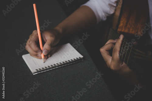 artist songwriter thinking writing notes,lyrics in book at studio.man playing live acoustic guitar relax chill.concept for musician creative.composer work process.people relaxing time with instrument photo