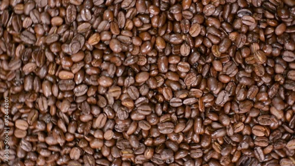Fragrant coffee beans scrolls slowly around the camera in slow motion Fragrant coffee beans scrolls slowly around the camera in slow motion