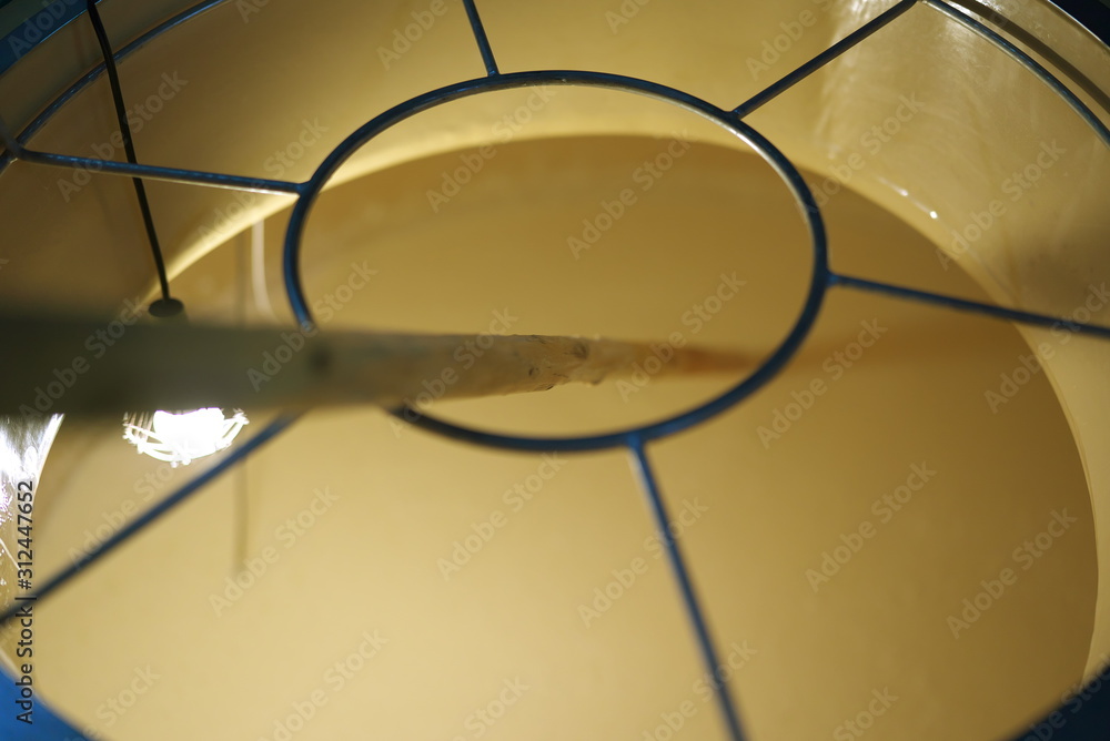 Tokyo,Japan-December 29, 2019: Mixing or stirring of fermentation mash of sake or seishu with a rod in a tank Tokyo,Japan-December 29, 2019: Mixing or stirring of fermentation mash of sake or seishu with a rod in a tank