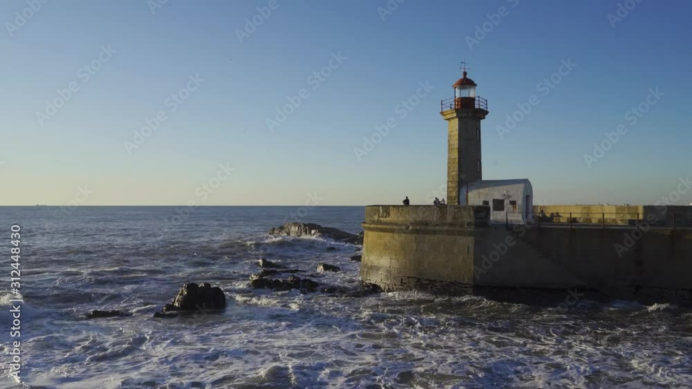 PORTO, PORTUGAL, December 2, 2019: very beautiful old lighthouse located on the mouth of the Douro river. Historic lighthouse facing some crushing waves in a soft winter light. PORTO, PORTUGAL, December 2, 2019: very beautiful old lighthouse located on the mouth of the Douro river. Historic lighthouse facing some crushing waves in a soft winter light.