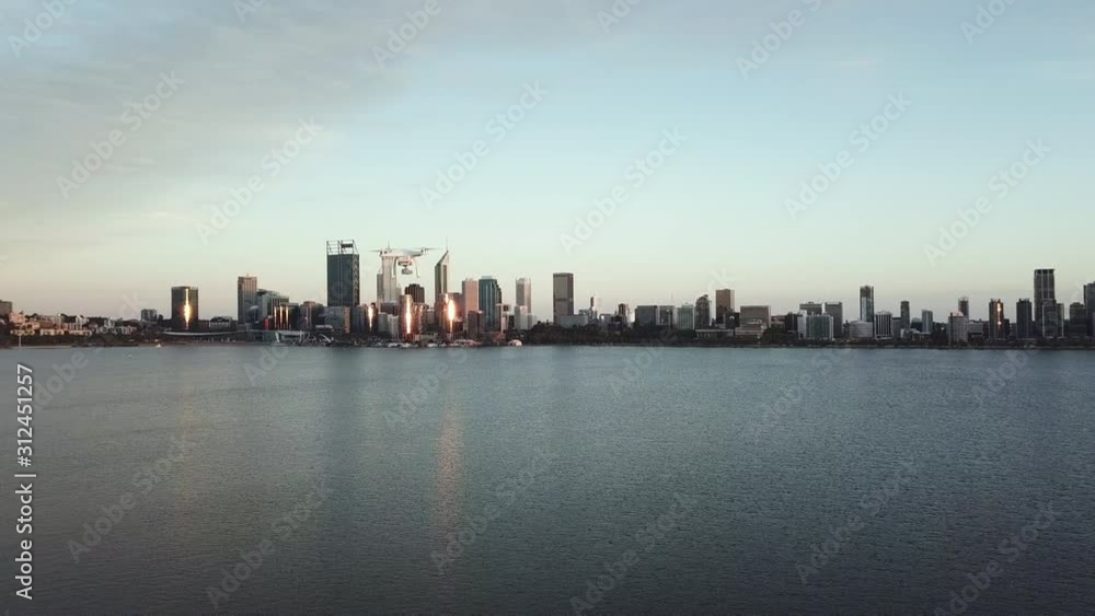 Aerial, actual drone flying across frame with highrise city and lake in distance Aerial, actual drone flying across frame with highrise city and lake in distance