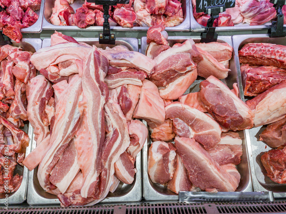 Assortment of pork meats in butcher shop's showcase in supermarket