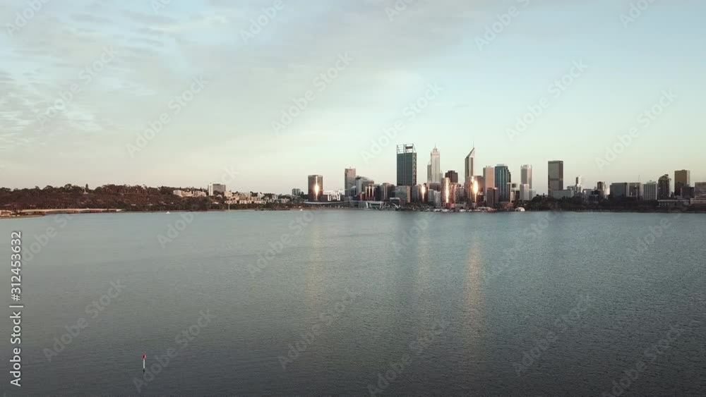 Aerial, white drone flying in foreground, city skyline and water in background Aerial, white drone flying in foreground, city skyline and water in background