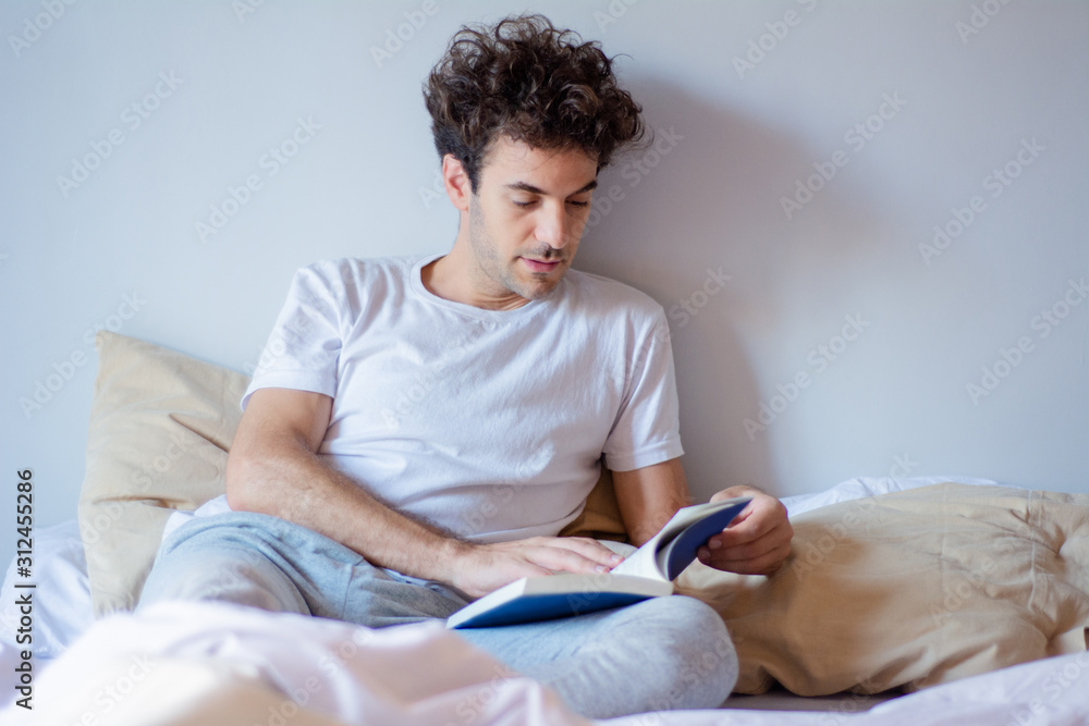 Man reading a book in bed Man reading a book in bed