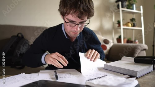 Crazy Hyperactive University Student on Caffeine Scribbling Notes While Studying for Exam photo