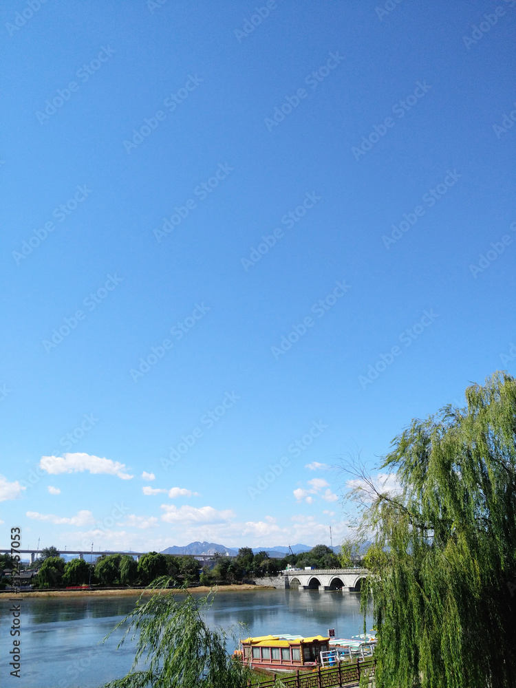Fototapeta premium Weeping willows and stone lions at Lugou Bridge