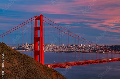 Fototapeta Naklejka Na Ścianę i Meble -  Panorama of the Golden Gate bridge with the Marin Headlands and San Francisco skyline at colorful sunset, California