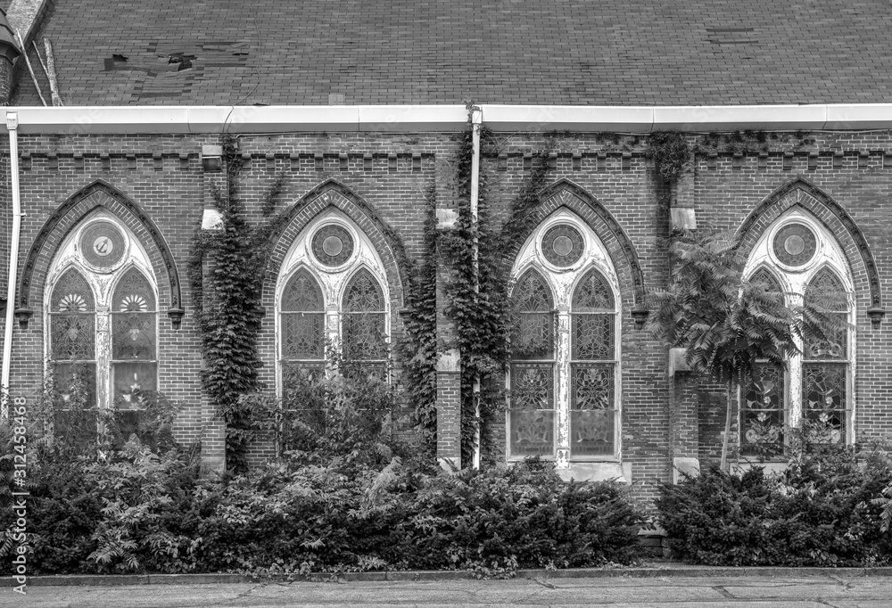 A facade of a brick church constructed in the 1880s in a state of disrepair A facade of a brick church constructed in the 1880s in a state of disrepair