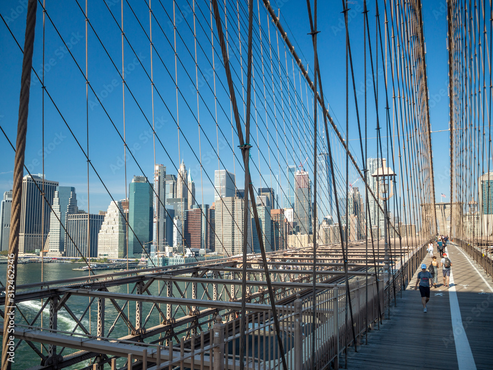 Obraz premium Brooklyn bridge, New York, USA - September 2019: [ Brooklyn bridge architecture with panoramic view of New York City and lower Manhattan, One World Trade Center, Dumbo ]