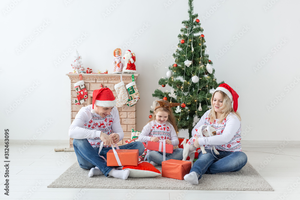 Holidays and presents concept - Portrait of a happy family opening gifts at Christmas time Holidays and presents concept - Portrait of a happy family opening gifts at Christmas time