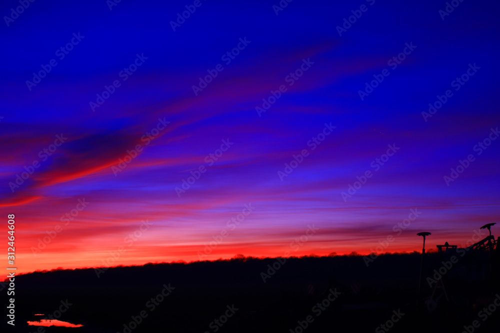 Very colorful clouds in dramatic sky. Romantic sunset at the countryside.