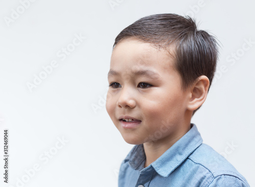 Portrait of a child in a blue shirt on a white background
