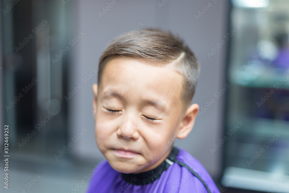 Close-up portrait of an attractive handsome smiling little boy looking at camera after haircut. Hair. Beautiful boy. Six year old boy smiling and having fun Close-up portrait of an attractive handsome smiling little boy looking at camera after haircut. Hair. Beautiful boy. Six year old boy smiling and having fun