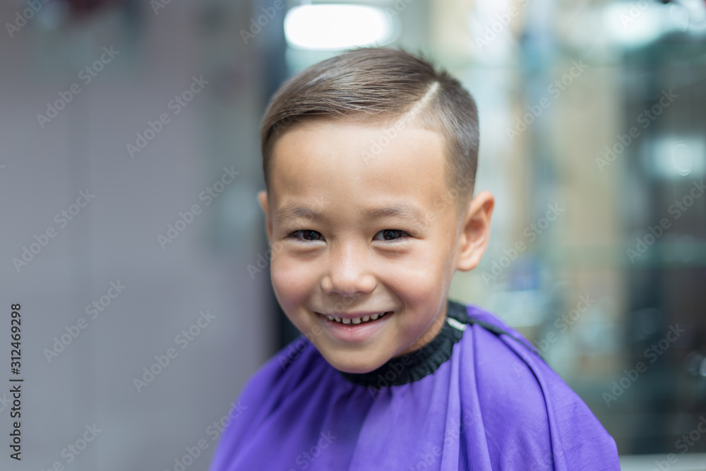 Close-up portrait of an attractive handsome smiling little boy looking at camera after haircut. Hair. Beautiful boy. Six year old boy smiling and having fun Close-up portrait of an attractive handsome smiling little boy looking at camera after haircut. Hair. Beautiful boy. Six year old boy smiling and having fun