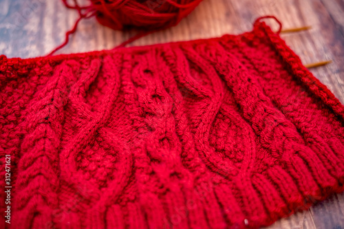  Selective focus and close up red knitted project and work in progress on a hardwood floor