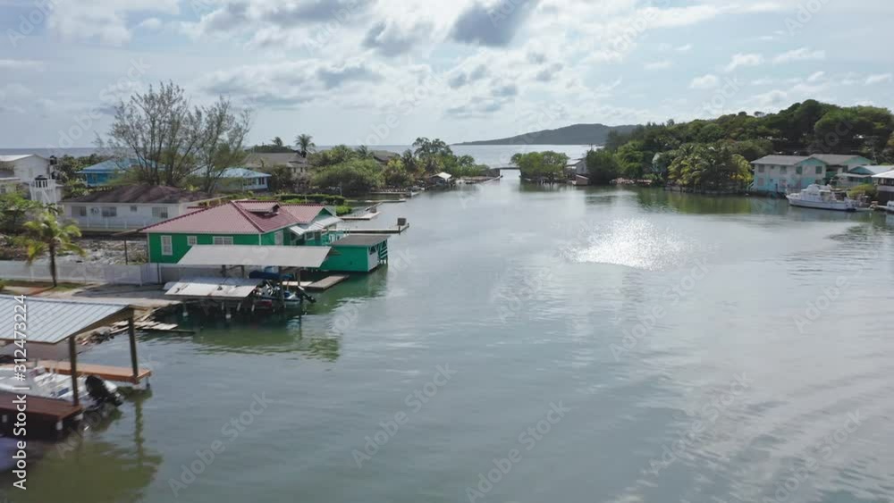 Aerial very low over water community towards bridge, rising out to ocean, Roatan Aerial very low over water community towards bridge, rising out to ocean, Roatan