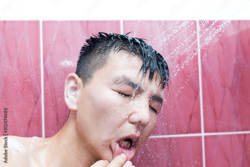 Asian handsome young man bathing in bathroom Asian handsome young man bathing in bathroom
