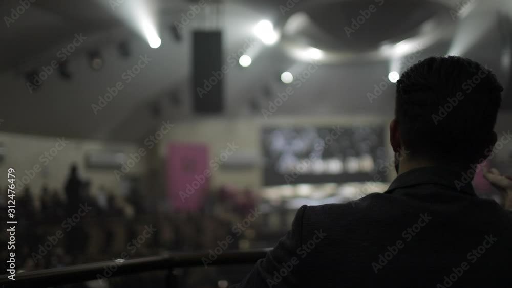 Silhouette of a man in a large conference room, backside view Silhouette of a man in a large conference room, backside view