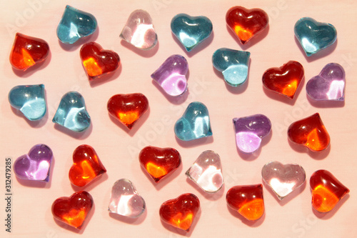 Glass red, blue and pink hearts on a pink background. Stock photo for valentine's day