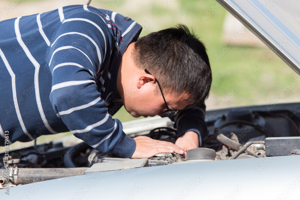 a man is repairing a car on the road