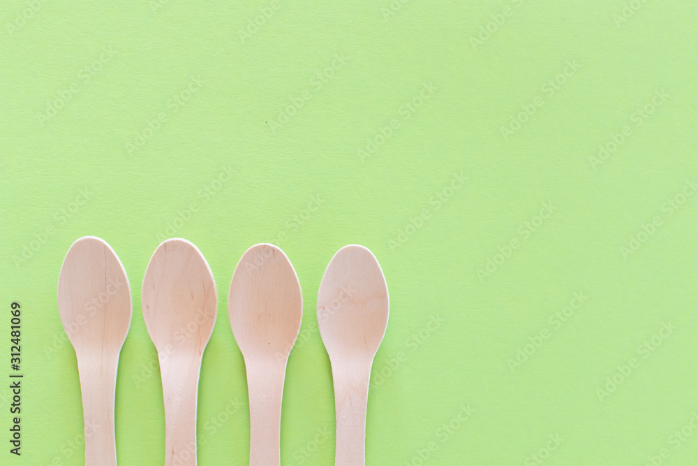 Spoon setup Cutlery on a bright green background. Eco-friendly wooden disposable cutlery on bright colored backdrop. Wallpapers for modern and ecological food. Plastic Free background Spoon setup Cutlery on a bright green background. Eco-friendly wooden disposable cutlery on bright colored backdrop. Wallpapers for modern and ecological food. Plastic Free background