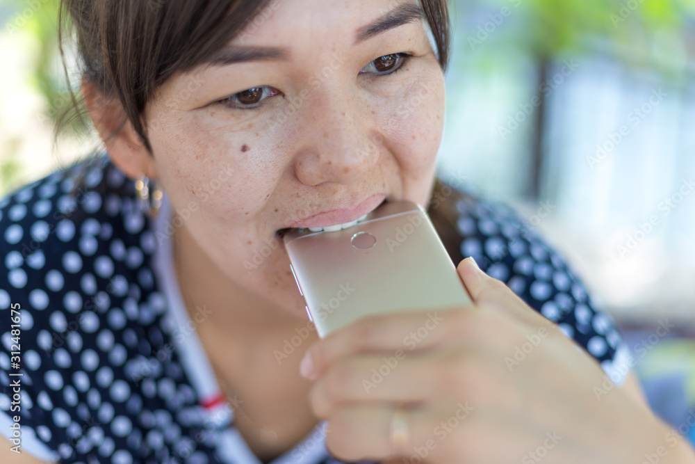 Woman bites smartphone with teeth from nerve Woman bites smartphone with teeth from nerve
