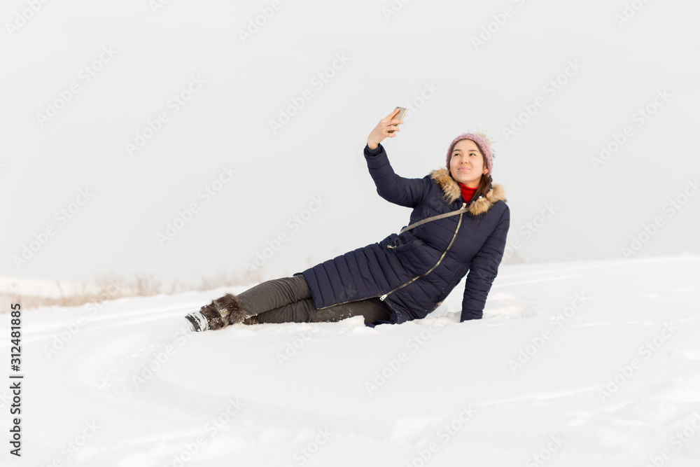 Portrait of a beautiful girl in blue jackets on the background of snow. Outdoor winter portrait Portrait of a beautiful girl in blue jackets on the background of snow. Outdoor winter portrait