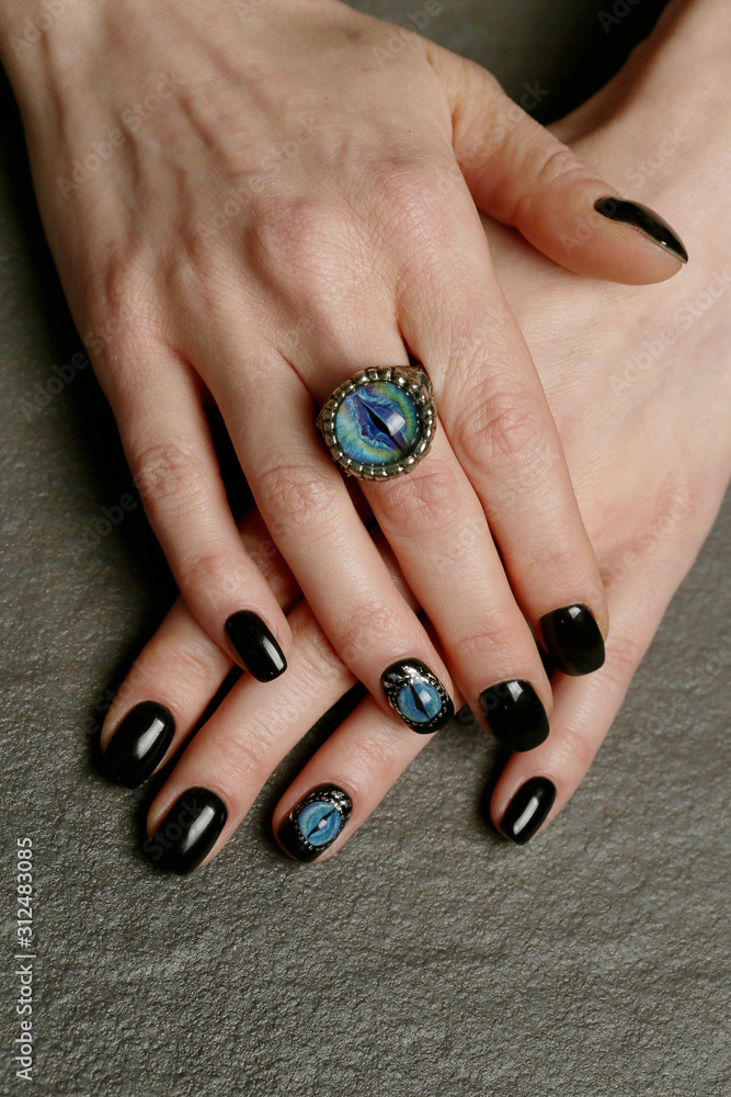 Unusual fantasy nail art and ring on manicured hands close-up Unusual fantasy nail art and ring on manicured hands close-up
