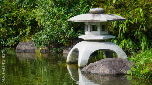 日本庭園の池に佇む石灯籠 The stone lantern in a traditional Japanese landscape garden 