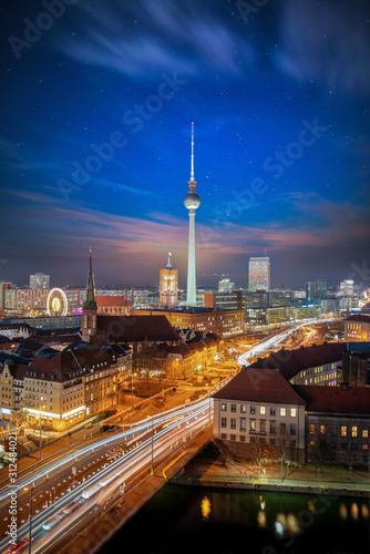 The skyline of Berlin, Germany, during dusk time with a starry sky and blurred traffic motion on the streets