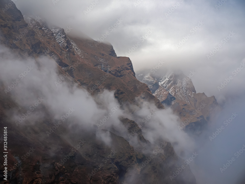Mountain range and deep gorge among the clouds in Himalayas