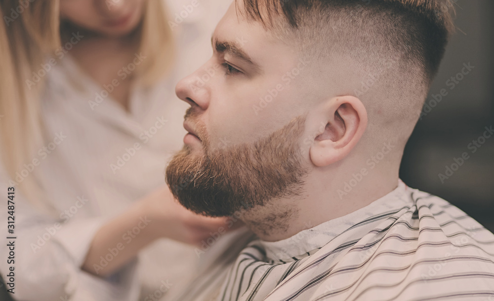 beautiful bearded man cutting the hair and beards in the barbershop beautiful bearded man cutting the hair and beards in the barbershop