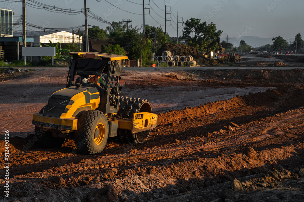 Obraz premium Soil compactor with vibratory padfoot drum. Heavy duty machinery working on highway construction site. Vehicle for soil compaction. Road construction equipment. Paving. Compaction of the road.