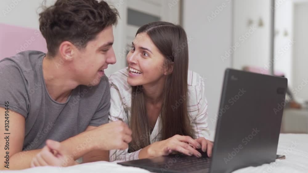 guy and girl rejoice in victory by seeing online on laptop guy and girl rejoice in victory by seeing online on laptop