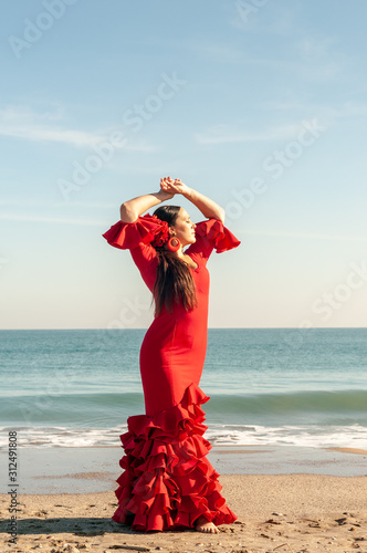 Young Spanish woman dancing flamenco on the beach