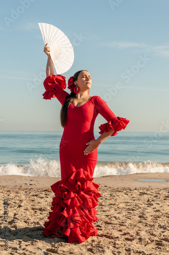 Young Spanish woman dancing flamenco on the beach