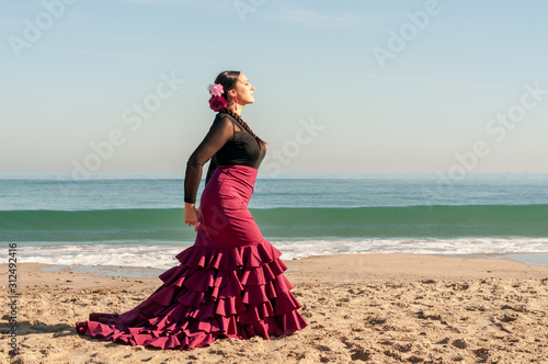 Young Spanish woman dancing flamenco on the beach