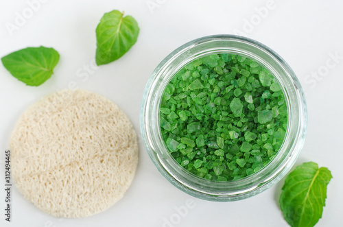 Green aroma bath salts (foot soak) in the glass jar. Natural beauty treatments. Top view, copy space.