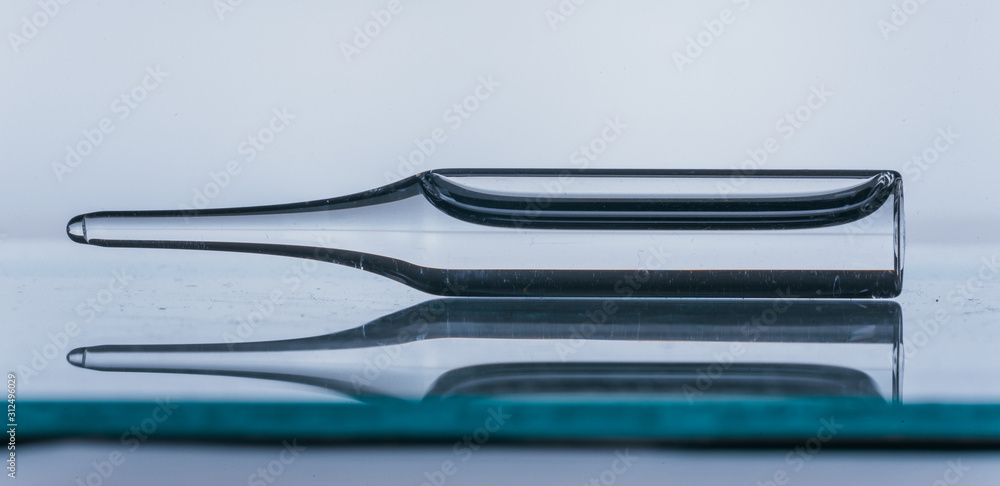Glass medical ampoule vial for injection. Medicine is dry white drug penicillin powder or liquid with of aqueous solution in ampulla. Close up. Bottles ampule with aluminum cap on backgrounds gray. Glass medical ampoule vial for injection. Medicine is dry white drug penicillin powder or liquid with of aqueous solution in ampulla. Close up. Bottles ampule with aluminum cap on backgrounds gray.