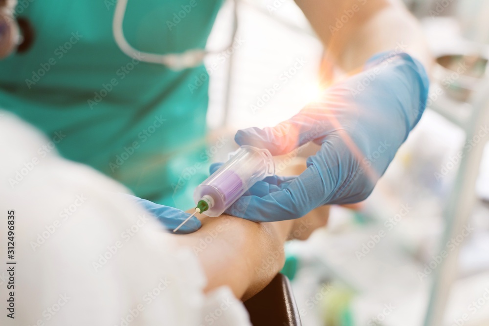 Nurse wearing gloves while injecting patient at hospital Nurse wearing gloves while injecting patient at hospital