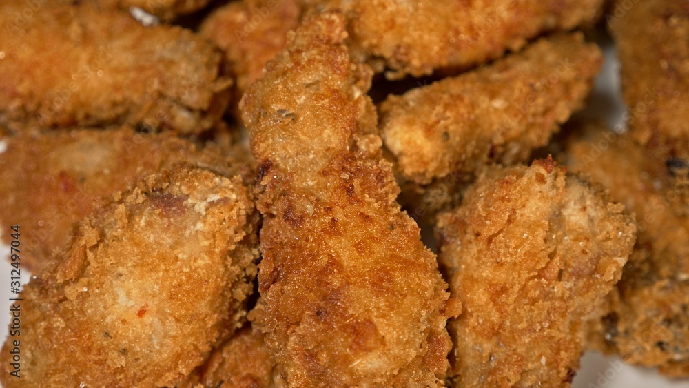 Cool beautiful fresh juicy cooked chicken wings in breading. Buffalo wings spread on food white plate in table. Very tasty and beautiful. Cooking with deep fryer fry machine. Cool beautiful fresh juicy cooked chicken wings in breading. Buffalo wings spread on food white plate in table. Very tasty and beautiful. Cooking with deep fryer fry machine.