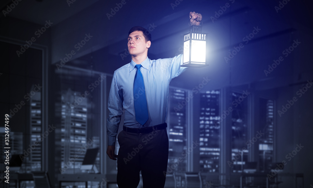 Fototapeta premium Scared businessman holding glowing lantern