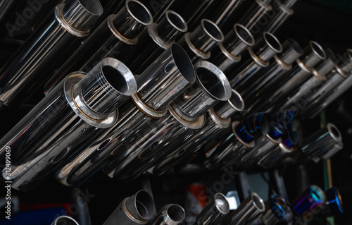 Obraz na plátne New and used motorcycle exhaust chrome pipes in a motorcykles shop or in service center