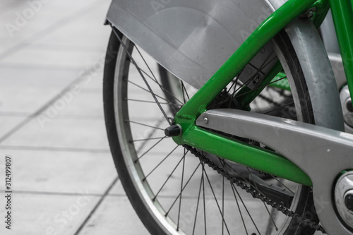 Street transportation green hybrid rent bicycles with electronic form of payment for traveling around the city stand in row on rental network parking lot waiting for cyclists to make bike trip.