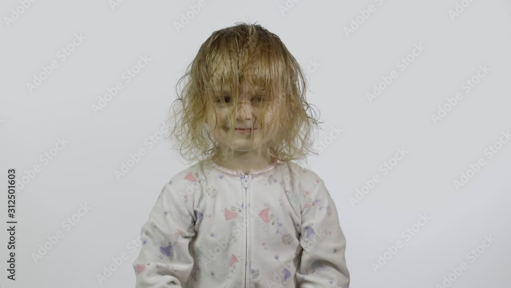 Little baby girl in pajama is fooling around and make faces. White background Little baby girl in pajama is fooling around and make faces. White background
