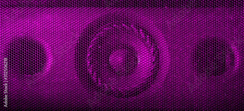 A close up macro photograph of a audio speaker using a pink magenta flash gel