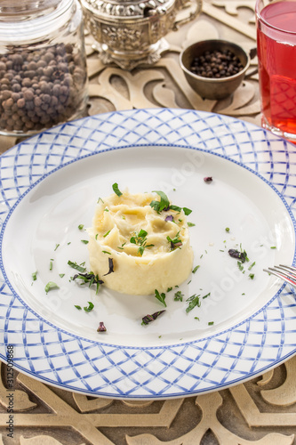 Mashed potato with dill and glass of red drink on orienral wooden table