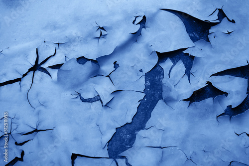 Foto Background of peeled off and discolored paint and a rusty surface under it toned in blue color which is the main trend of the year 2020